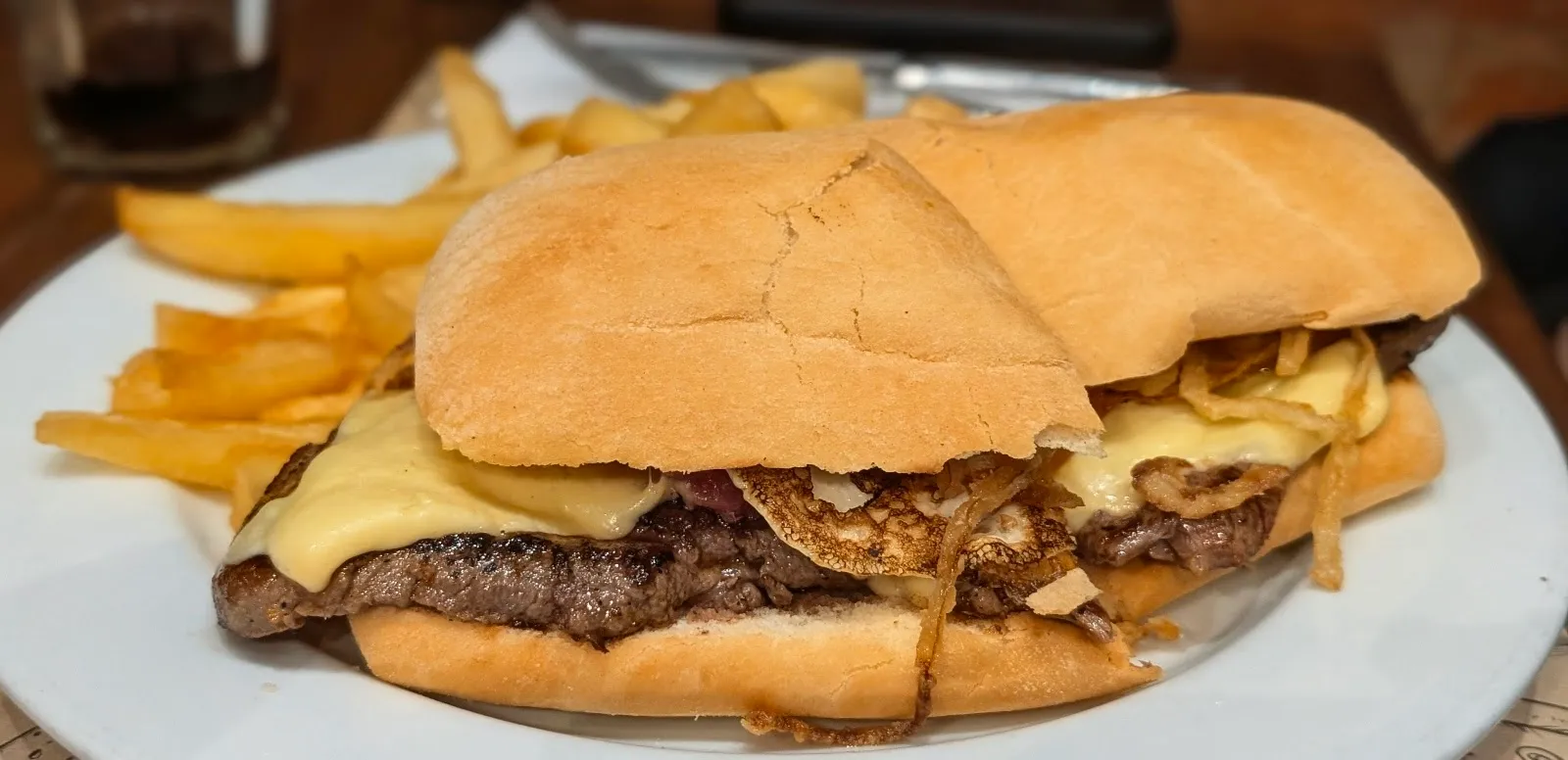 Sándwich de lomo con queso fundido y papas fritas en Biblos